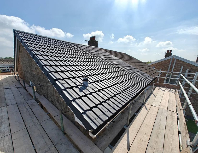 Finished dark tile roof viewed from scaffolding