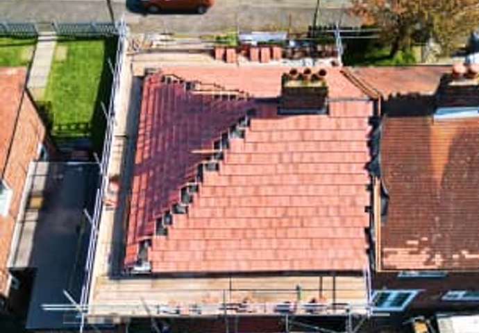Aerial view of red tile roof replacement in progress
