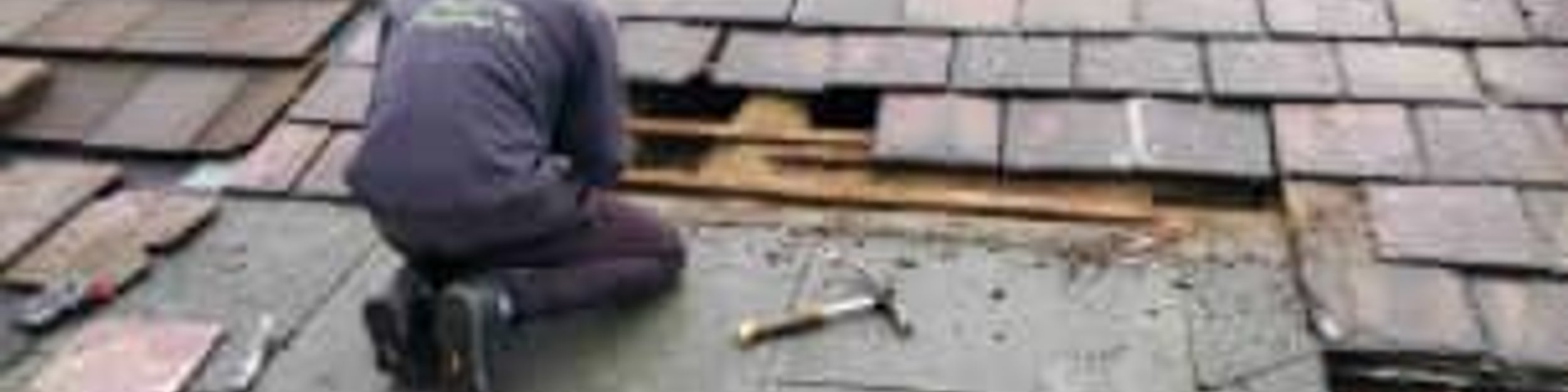 Roofer installing asphalt shingles on roof