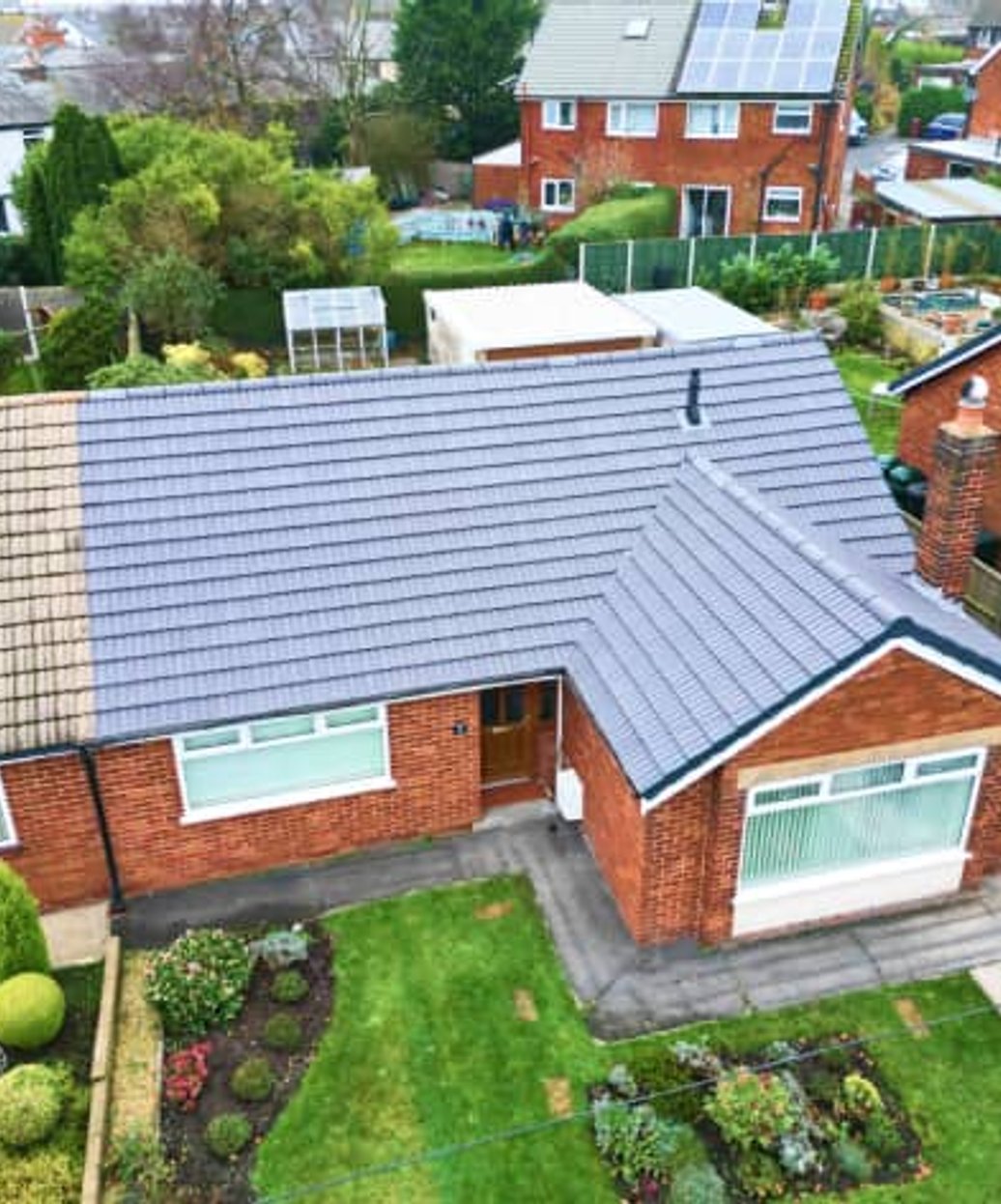 Aerial view of brick home with gray tile roof