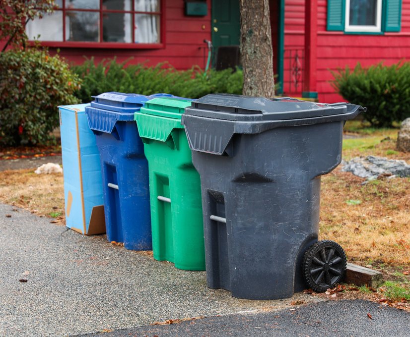 Row of waste and recycling bins on driveway